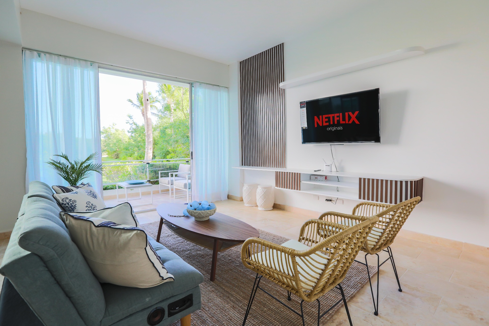 Interior de apartamento 3 habitaciones en Cap Cana gestionado por Bellamar — sala con vista al jardín tropical